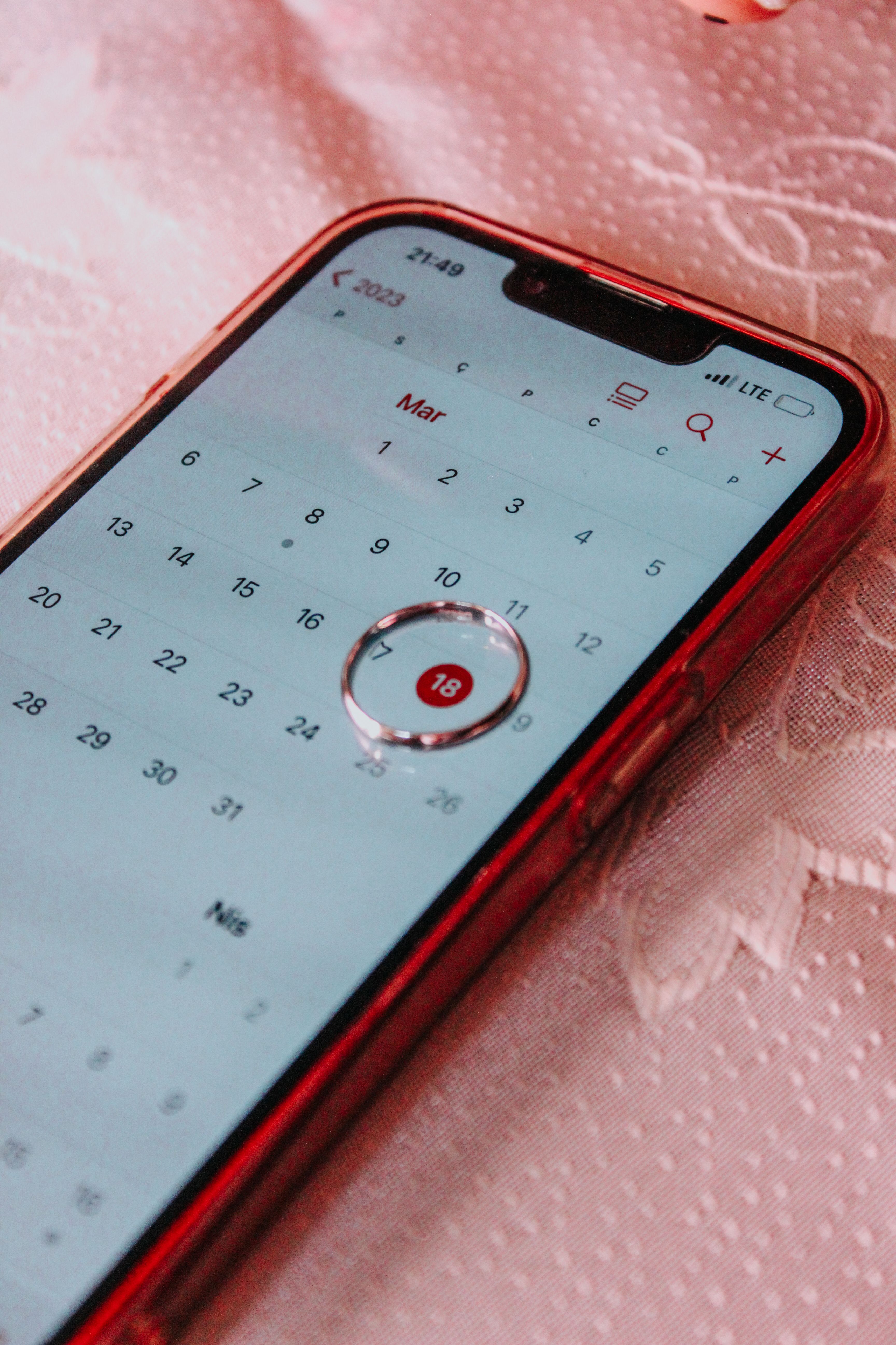 A smartphone displaying a calendar with March 18th highlighted, signifying an important date.