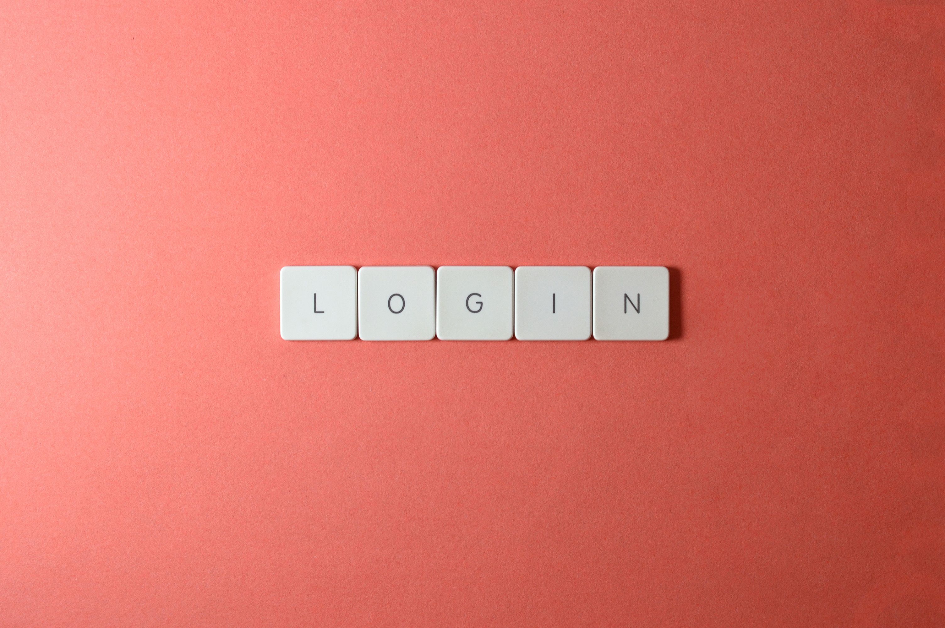 Close-up of login keyboard tiles on a coral background, perfect for tech themes.