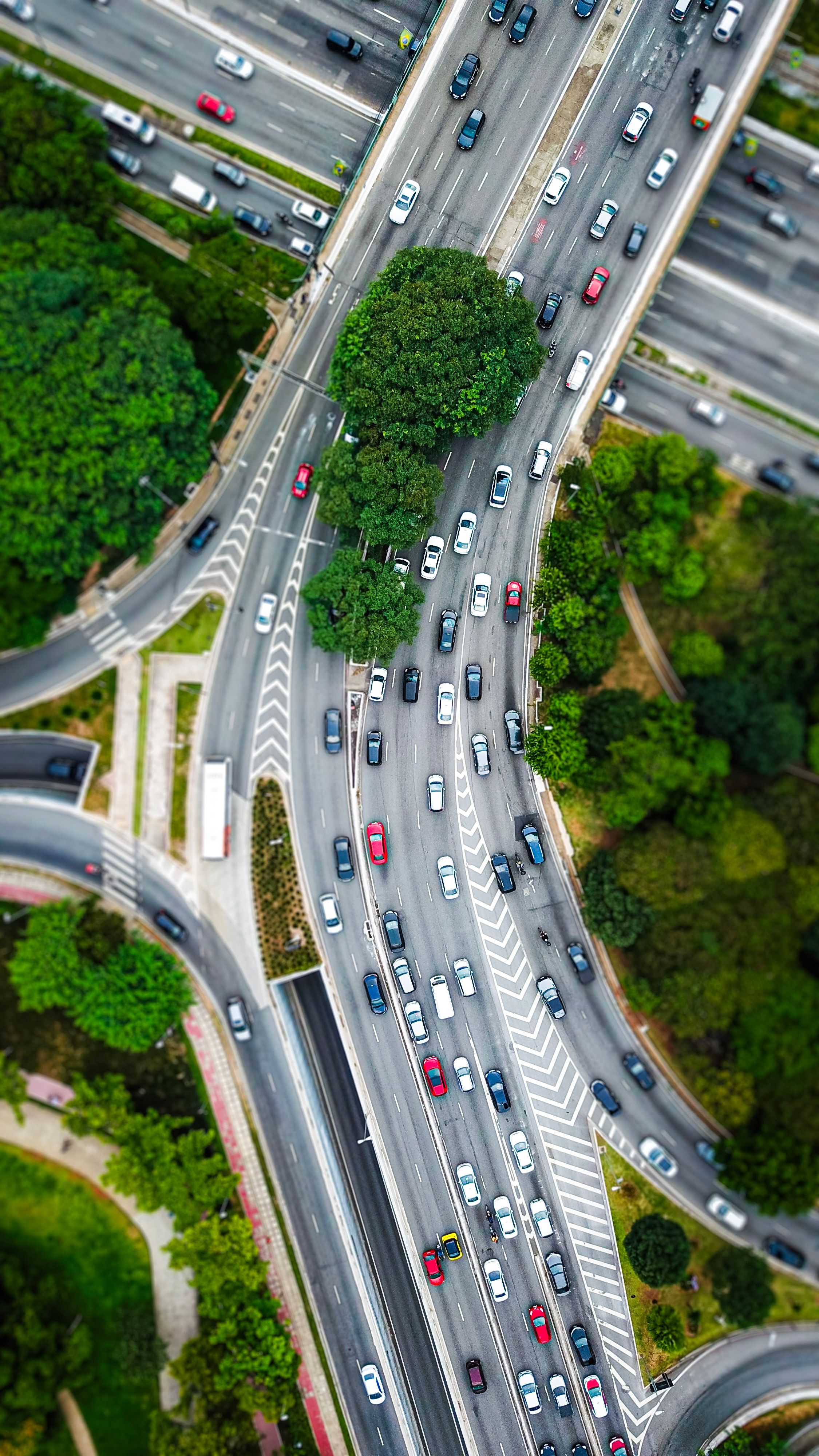 Aerial shot of a bustling highway intersection surrounded by greenery.