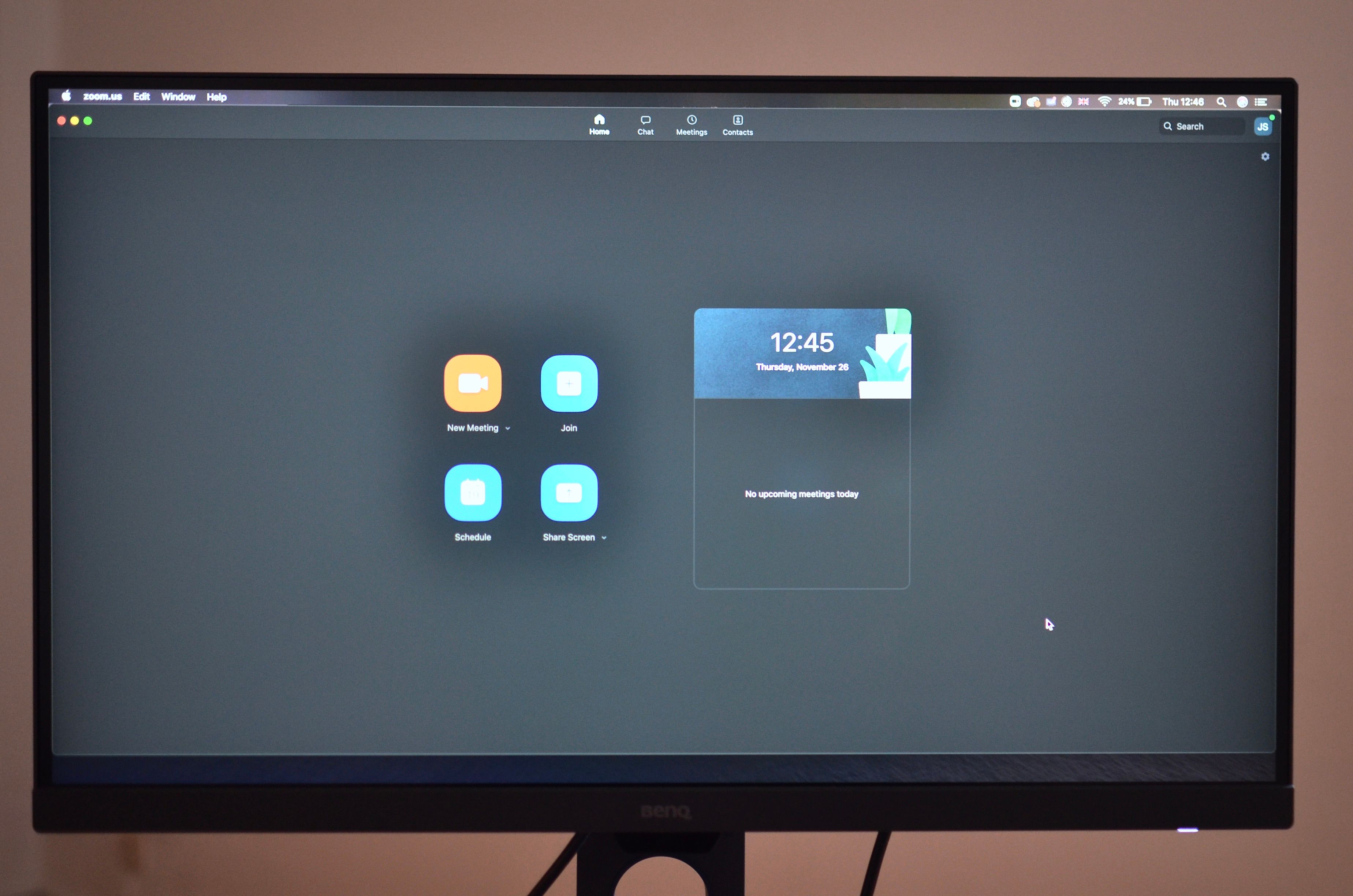Contemporary stationary black rectangular monitor showing time on display with wires placed on brown background at convenient workplace in room